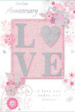 This tender anniversary card is a gentle celebration of enduring romance, combining soft pastel pinks and cool silvery greys in a way that feels as calm and intimate as a quiet evening walk through Stratford's tree-lined streets. At its heart, the word LOVE stands proudly in soft, raised glitter, the letters shaped with rounded edges that give them a comfortable, welcoming feel. The O is transformed into a shimmering silver heart, densely textured so it glows a little brighter than the other letters, becoming the emotional centre of the design. Surrounding this emblem, delicate blossoms in blush, mauve, and pale ivory float across the card, painted or illustrated with a watercolour softness that allows the colours to bleed slightly into one another. Fine, flowing lines suggest curling stems and gentle vines, giving the impression of an English spring garden caught just at the moment it begins to bloom. Tiny flourishes-scatterings of petals, subtle curls, and almost invisible butterflies-add a sense of playful motion, as though a light breeze has just brushed past a vase of flowers. The background remains a soft wash of pink with hints of grey, enhancing the dreamy, romantic mood. In a graceful, understated script, the phrases On Our Anniversary and I love you today and always are written around or beneath the central motif, their flowing letters reinforcing the sincerity of the message. The overall composition feels like a whispered promise in card form, perfectly suited to be tucked beside a bouquet delivered to a Stratford home, restaurant, or riverside celebration to mark another year of shared life and love.